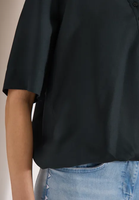 Schwarze Bluse mit 3/4-Ärmeln kombiniert mit hellblauen Jeans