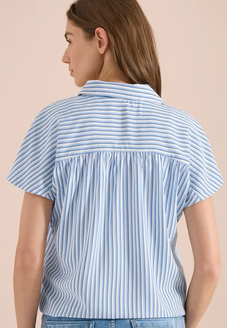 Frau von hinten in blau-weiß gestreiftem Kurzarmhemd mit Rückenpasse und Falten
