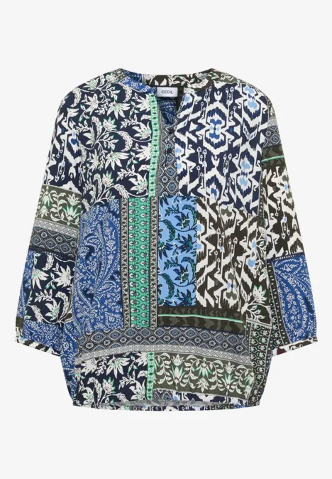 Locker geschnittene Bluse mit buntem Patchwork-Muster in Blau, Grün und Weiß.