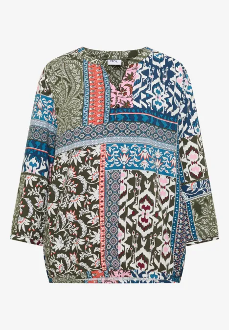 Locker geschnittene Damenbluse mit buntem Patchwork- und Blumenmuster, langen Ärmeln.