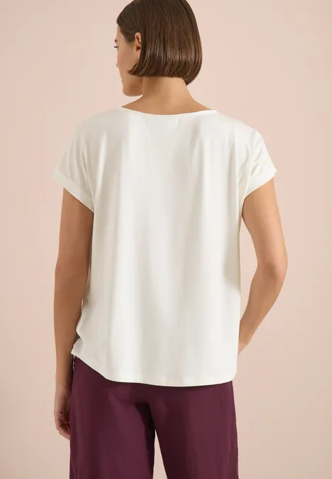 Blouse met ronde hals en knoopdetail vanilla white vrouw achteraanzicht in wit kort mouw t-shirt en bordeauxrode broek