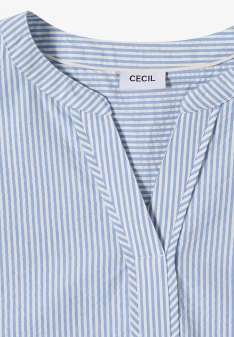 T-shirt féminin bleu clair et blanc à rayures avec col en V et étiquette 'CECIL'.