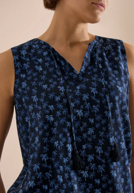 Robe sans manches bleu marine à motif de palmiers bleu clair, encolure en V ornée de liens à pompons.