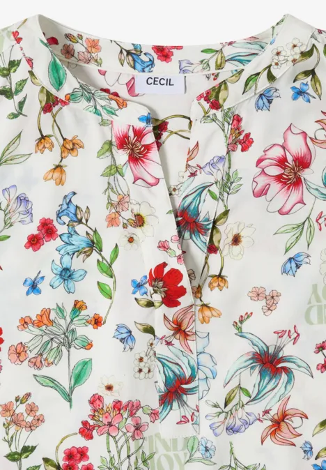 Weiße Bluse mit buntem Blumenmuster und kleinem Schlitz am Ausschnitt.