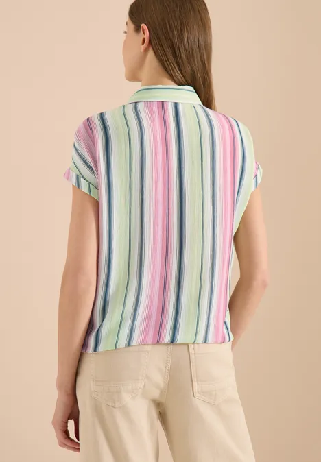 Overhemdblouse met strepen en knopen vanilla white Vrouw van achteren in een kort mouwpolo met pastelkleurige strepen en een lichtgekleurde broek.