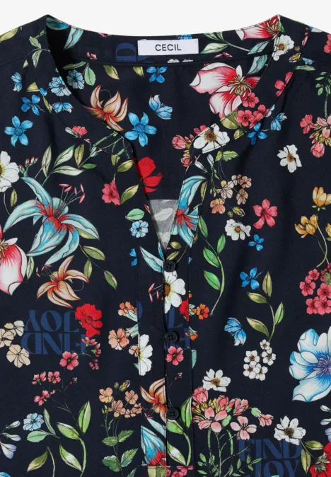 Chemisier à manches 3/4 avec col fendu et imprimé universal blue Blouse bleu foncé à encolure en V boutonnée, ornée d’un motif floral coloré.
