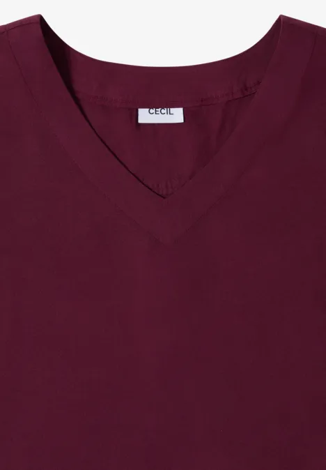 Ein schlichtes, dunkelrotes V-Neck-Shirt, flach liegend.