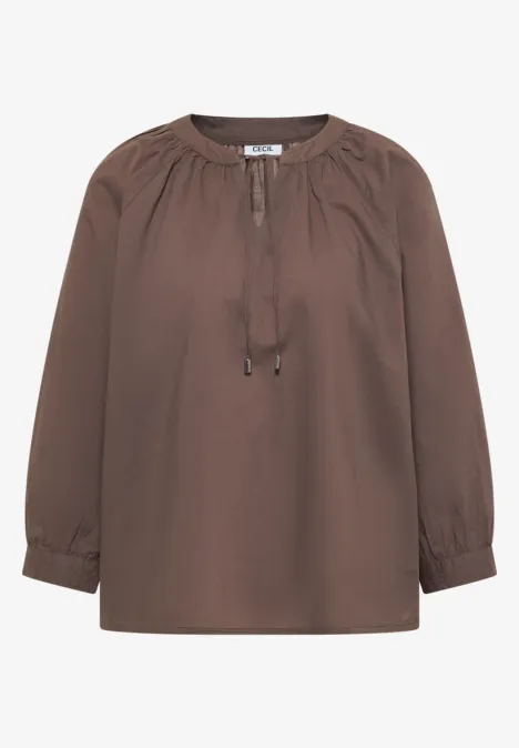 Bruine blouse met lange mouwen en koordsluiting bij de hals.