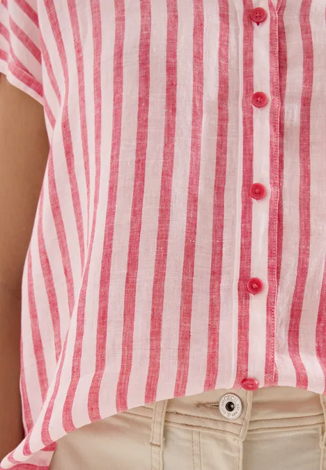 Rotes-weiß gestreiftes Hemd mit roten Knöpfen, lässig über helle Hose drapiert.