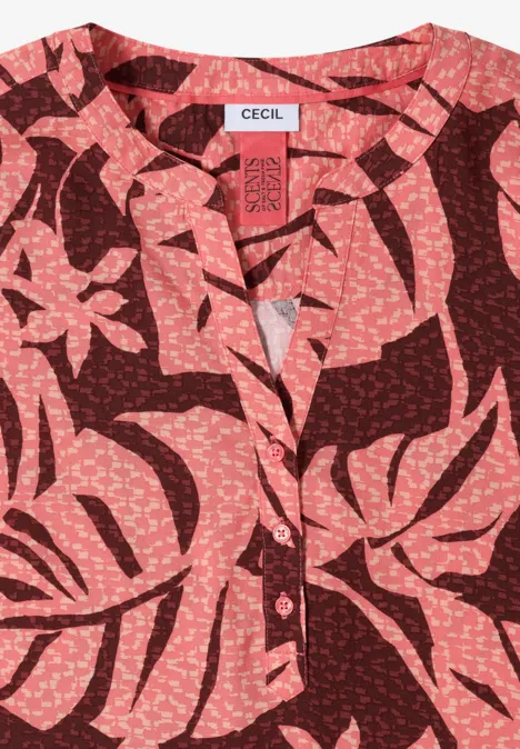 Rote Bluse mit rosenfarbenem, tropisch-inspiriertem Blattmuster.
