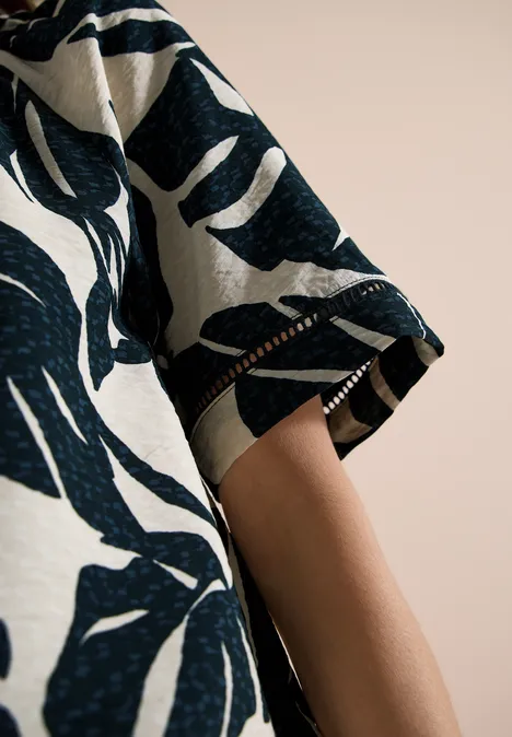 Carmen-Bluse mit Kurzarm und Blätterprint palm breeze green Kurzärmeliges Oberteil mit dunkelblauem Blattmuster auf hellem Stoff.