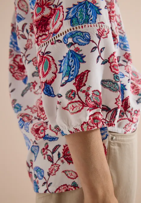 Weißes Shirt mit buntem Rot-Blau-Blumenmuster und lockerem Puffärmel