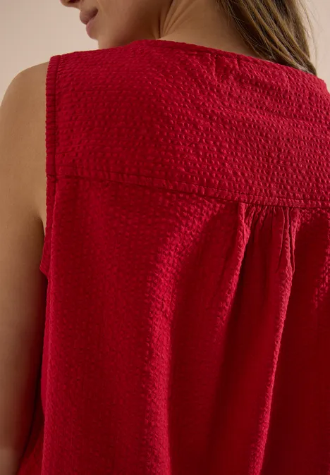 Blusentop mit Split Neck und Bändern tamarillo red Rückenansicht einer Frau in ärmelloser, rot-texturierter Bluse.