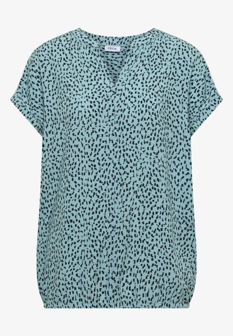 Leichtes türkises Blusenshirt mit schwarzem Tupfenmuster, V-Ausschnitt und kurzen Ärmeln.
