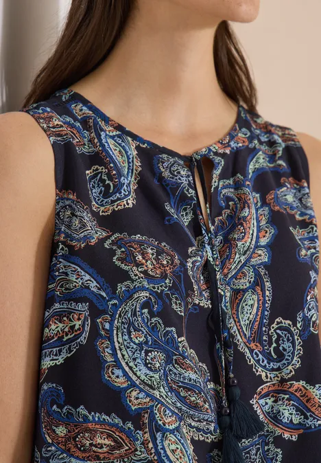 Dunkelbluse mit Paisley-Muster in Blau- und Orangetönen, ärmellos mit kleinem Schlitz am runden Ausschnitt.