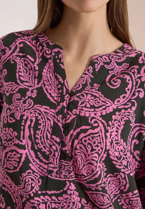 Tuniek met 3/4-mouwen en print raw khaki Close-up van een zwarte blouse met roze paisleyprint en V-hals.
