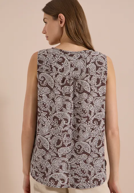 Femme vue de dos portant un top sans manches bordeaux à motif cachemire blanc.