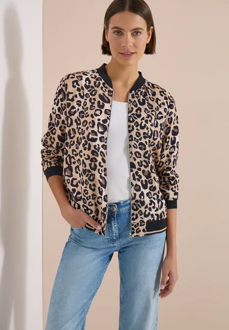 Leichter Blouson mit Zipper und Leo-Print urban taupe Frau trägt eine Leopardenmuster-Blousonjacke, weiße Bluse und Jeans.