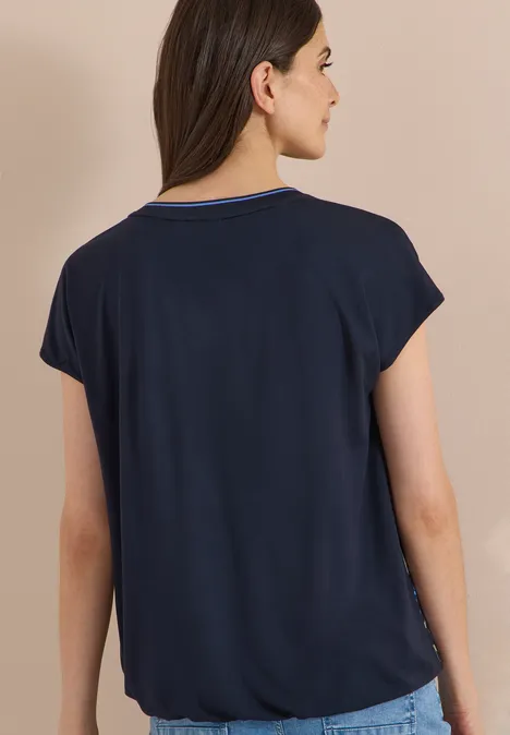 Chemisier à manches courtes avec mélange de textures urban dark blue Frau trägt marineblaues kurzärmeliges Oberteil mit V-Ausschnitt, Rückansicht.