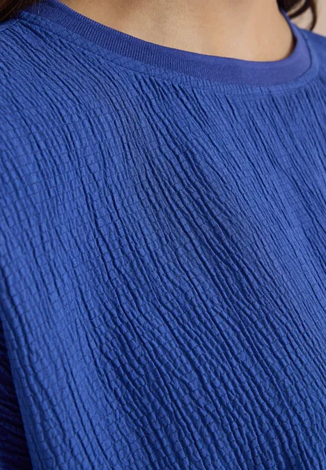 Chemisier à épaules tombantes, couleur unie deep river blue Nahaufnahme eines blauen, texturierten Shirts mit feinem Rippmuster und Rundhalsausschnitt.