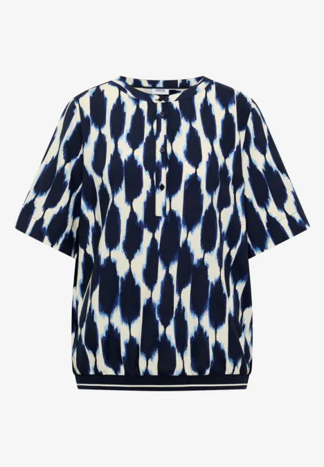 Weiß-blau gemustertes Kurzarmshirt mit rundem Ausschnitt und Knopfleiste.