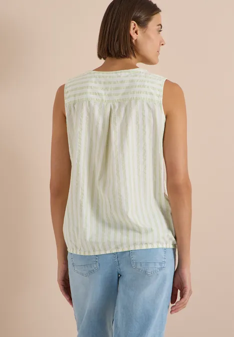 Seersucker Blusentop mit Streifen raw matcha lime Frau von hinten in ärmellosem, pastell-gestreiftem Top und blauen Jeans.