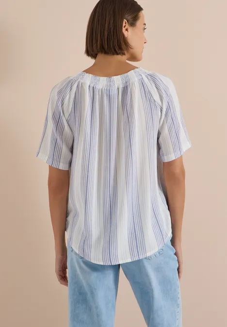 Carmen-Bluse mit Streifenmuster deep river blue Frau von hinten in einer lockeren, kurzärmligen, weiß-blau gestreiften Bluse mit heller Jeans.