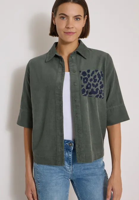 Overhemd met korte mouwen van corduroy met borstzak dried olive green Frau trägt khakifarbenes Hemd mit Leopardenmuster-Tasche, weißes Shirt und Jeans.