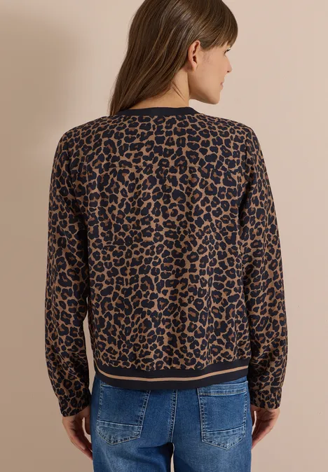 Blouson mit Zipper und Leo-Muster creamy mocha Frau von hinten in einem Leo-Print-Pullover vor neutralem Hintergrund.