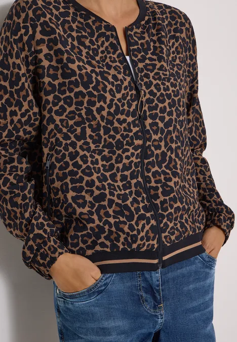 Blouson mit Zipper und Leo-Muster creamy mocha Bomberjacke mit Leopardenmuster, Reißverschluss und Taschen, kombiniert mit Jeans.