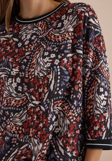 Blouse met 3/4-mouwen en print raw chocolate brown Donkere top met abstract bloemenpatroon in rood, wit, blauw en zwart.