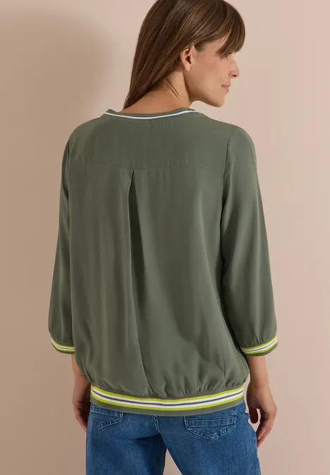 Blouse met 3/4-mouwen en contrasterende details dried olive green Vrouw van achter in losvallende groene blouse met 3/4-mouwen, plissé op de rug en gestreepte zoom.