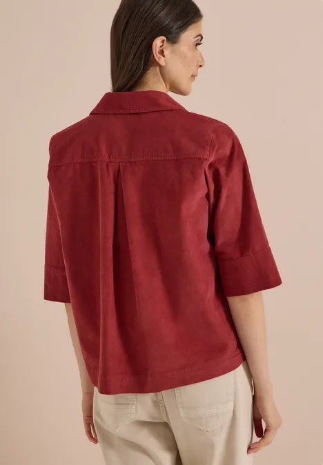 Overhemd met korte mouwen in effen kleur russet red Vrouw rugzijde in rode 3/4-mouw overshirt en beige broek.