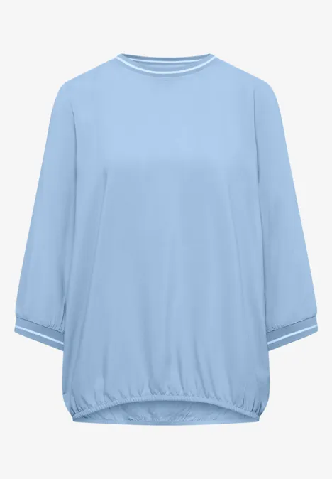 Hellblaues Oversize-Shirt mit 3/4-Ärmeln und Rundhalsausschnitt.