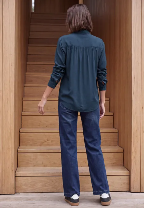 Langarm Hemdbluse mit Knopfleiste moonlight blue Person in Jeans und dunklem Hemd geht eine Holztreppe hinauf, Rücken zur Kamera.