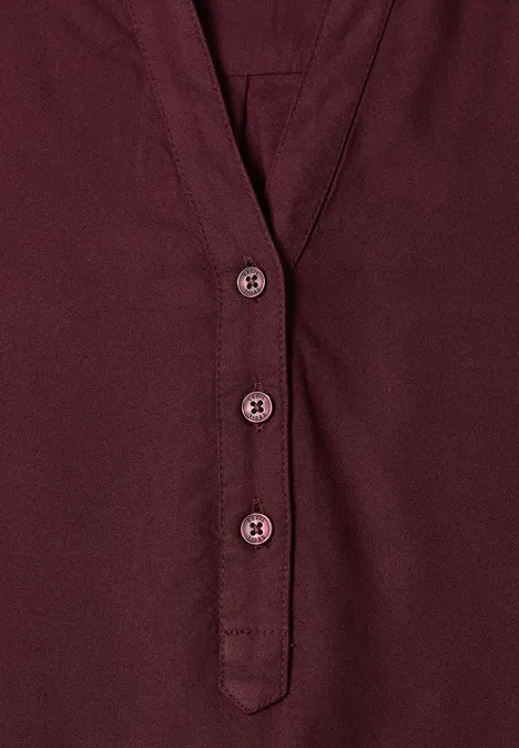 Bordeauxrood shirt met V-hals en drie bijpassende knopen.