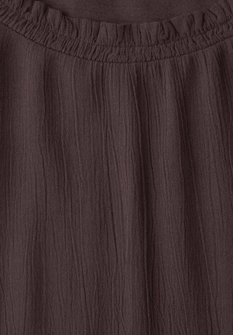 Blouse marron foncé à col rond froncé, texture froissée et légère.