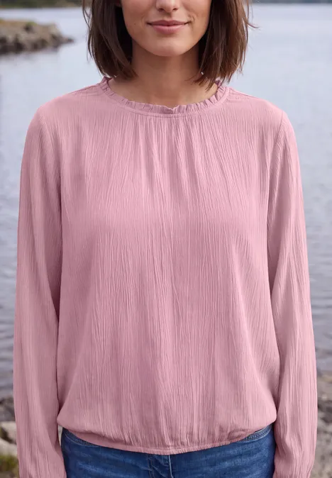 Langarm Bluse mit Rundhals und Smokdetail mellow rose Frau in rosa Bluse, stehend vor einem See, Oberkörper von Kinn bis Taille sichtbar