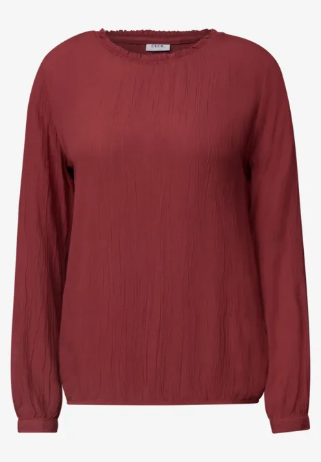 Blouse à manches longues et col rond avec détails smockés russet red Chemisier rouge à manches longues, coupe ample et texture froissée.