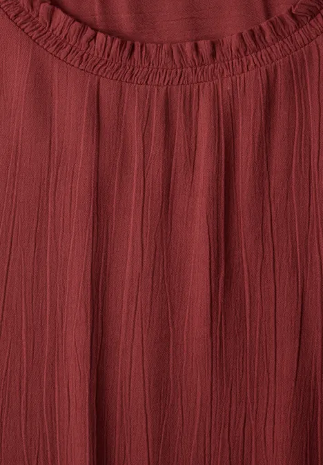 Blouse à manches longues et col rond avec détails smockés russet red Haut en tissu rouge froncé avec encolure ronde élastique.