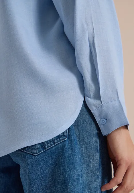 Langarm Tunika mit Split Neck und Tape blouse blue melange Seitansicht eines Oberkörpers in hellblauem Hemd und blauen Jeans