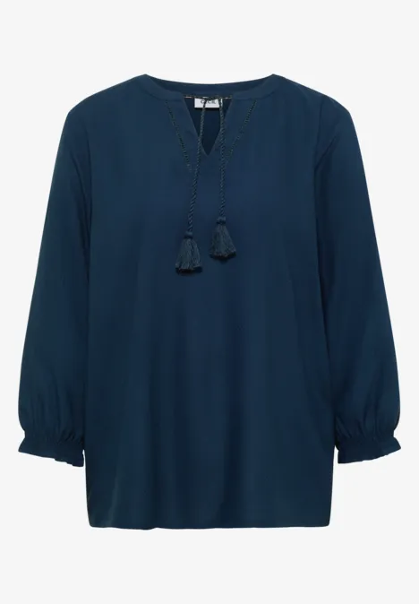 Dunkelblaue Bluse mit langen Ballonärmeln und V-Ausschnitt mit dekorativen Quasten.
