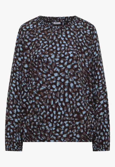 Damesblouse met zwarte basis en blauw abstract bladpatroon, lange mouwen, losse pasvorm.