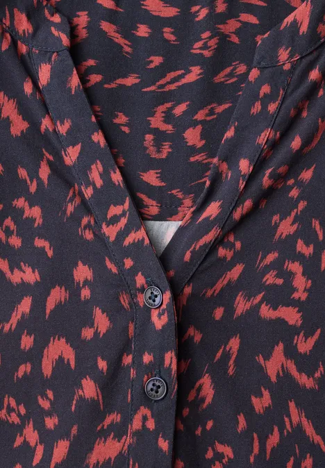 Tunique à manches longues, à col fendu et imprimé urban dark blue Blouse noire à motifs rouges abstraits, encolure en V et boutons.