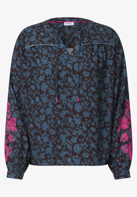 Dunkelbluse mit blauem Blumenmuster, langen Ärmeln mit pinken Stickereien und Tunnelzug am V-Ausschnitt.