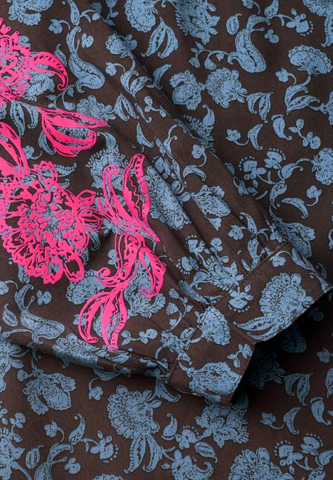 Nahaufnahme eines braunen Stoffes mit blauem Blumenmuster und pinker Blumenstickerei.