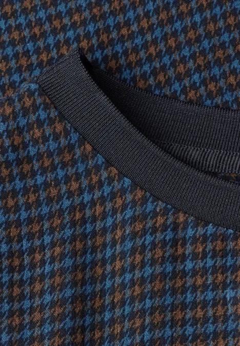 Langarm Bluse mit Rundhals und Print urban dark blue Nahaufnahme eines Strickpullovers mit blau-braunem Hahnentrittmuster und schwarzem Rippenstrickkragen.