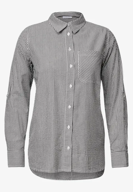 Chemise à manches longues rayée noir et blanc, col classique, poche poitrine et patte de boutonnage.