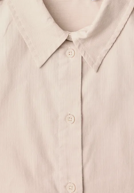 Chemisier à manches longues en velours côtelé uni cashmere beige Gros plan d’une chemise beige clair avec col et patte de boutonnage.