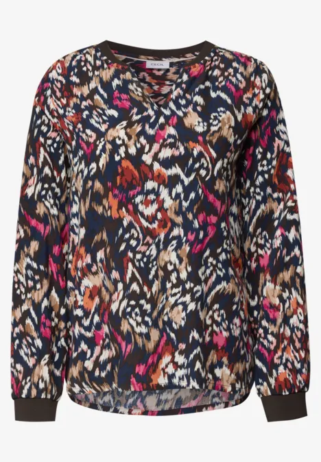 Blouse femme décontractée à manches longues, motif abstrait coloré.